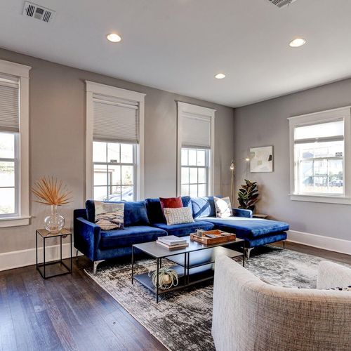 Bright, airy living room w/ plush blue sofa — perfect for the whole group to kick back & relax.