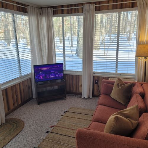 Living room #2:  the cabin has a section that was added on to the original cabin that now includes a sofa, lots of windows, and a smart television with roku.