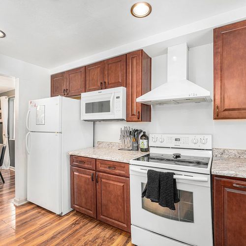 - whip up meals with ease in this fully equipped kitchen with modern essentials
- rich wooden cabinetry and crisp white appliances give a warm, homey vibe
- seamless flow to the dining area makes entertaining feel effortless and fun