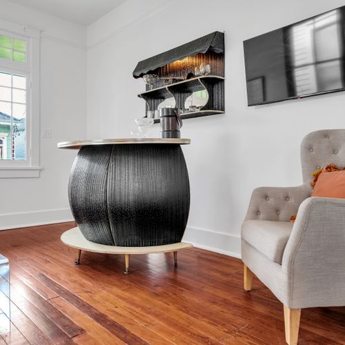 Striking bar island w/ a sculptural base & rich warm wood floors.
