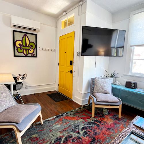 Eclectic living room w/ bold decor, a teal sofa & warm wood floors.