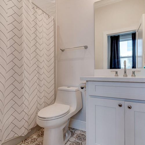 Clean, bright bathroom w/ a sink, toilet & tub — everything you need.