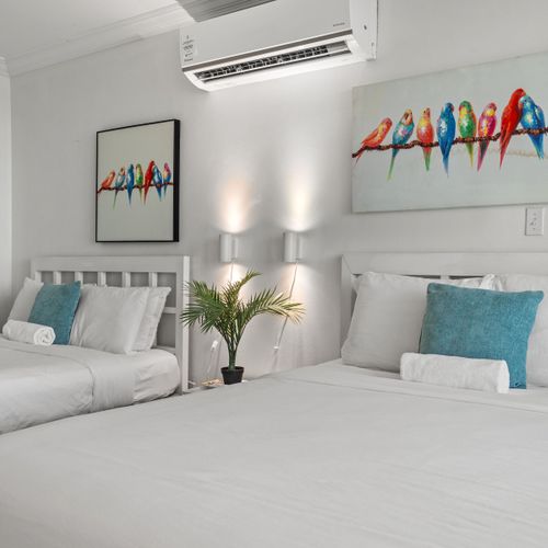 Sleep soundly in this comfortable bedroom with two perfectly arranged beds. Delightful artwork and soft lighting ensure a restful stay.