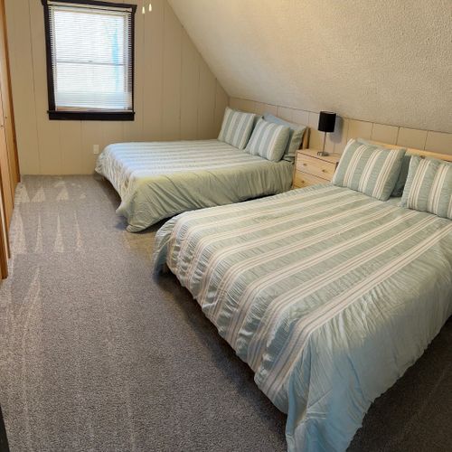 Bedroom #3 (upstairs):  features two queen beds, a ceiling fan, a nightstand, a lamp, and 2 large closets.