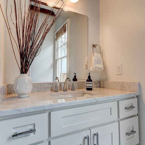 Half bath w/ a clean sink vanity & soft natural light.