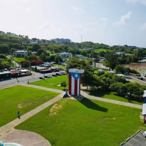 Experience Puerto Rico! Admire this impressive flag monument set against a bright, sunny backdrop.