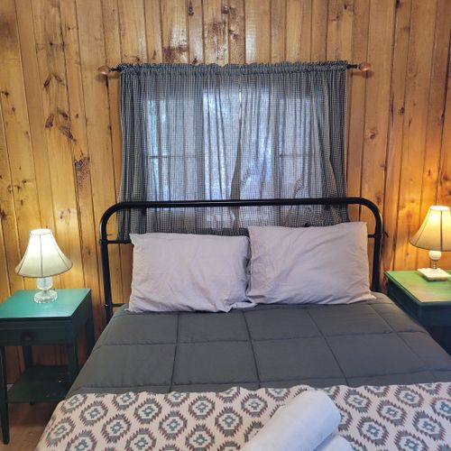 Bedroom #1:  features a queen-size bed, nightstands, lamps, a dresser, and a mirror.