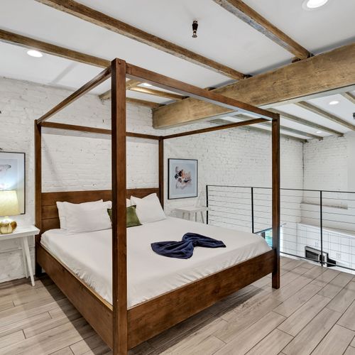 Sunlight pours into the lofted bedroom overlooking the open living room, blending charm and comfort in a space as vibrant and elevated as the Crescent City itself.