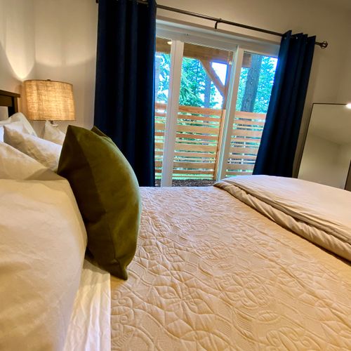 Wake up gently — the primary bedroom opens to the forest through a private sliding door.