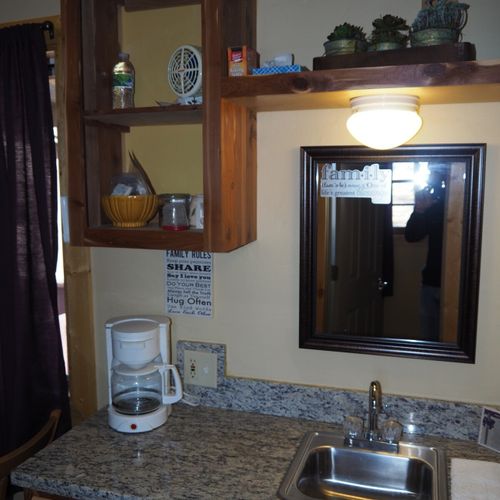 Main room:  includes two twin-on-twin bunk beds, a small dining table, chairs, and a kitchenette / sink.