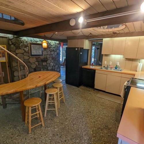 Overall:  the kitchen with all the basic cooking appliances including a dishwasher and coffeemaker along with a wooden table and stools