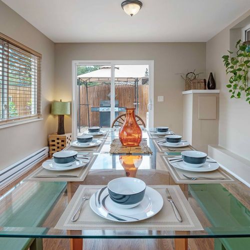- gather around this stunning glass top table styled for memorable feasts
- beautifully set for eight with sleek tableware and a glowing amber centerpiece
- slide open the doors and fire up the grill for the perfect indoor outdoor meal