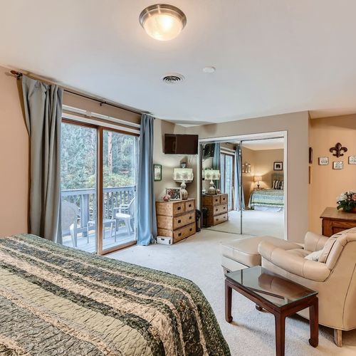 The master bedroom provides a plush leather armchair complete with an ottoman, and several dressers for storage.