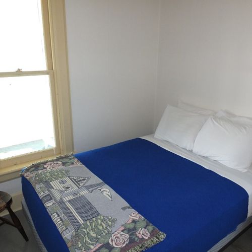 Bedroom #2 (main floor):  features a full-size bed, mirror, dresser, and closet.