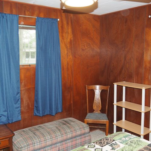 Bedroom #1:  features a queen-size bed, dresser, chair, lamps, and a ceiling fan.