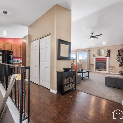 - entryway opens to a bright living space with fireplace, neutral tones, and warm wood floors
- black railing and storage console keep the layout stylish and functional
- great flow between kitchen, living room, and bedrooms throughout