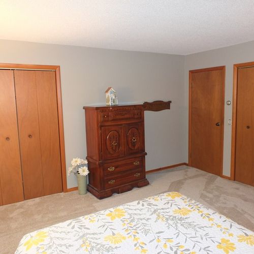 Bedroom #1:  features a queen-size bed, chair, nightstand, lamp, dresser, and 2 closets.