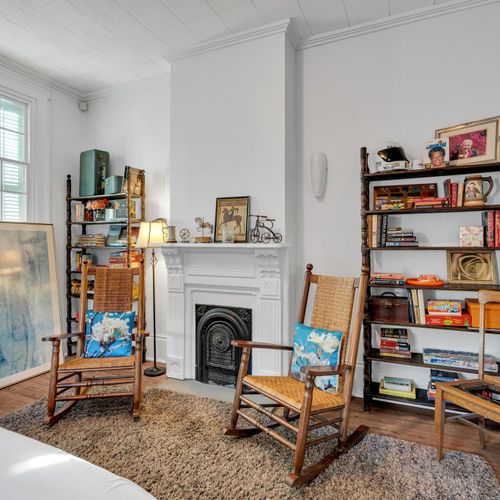 Classic NOLA living room w/ a cozy fireplace as its centerpiece.