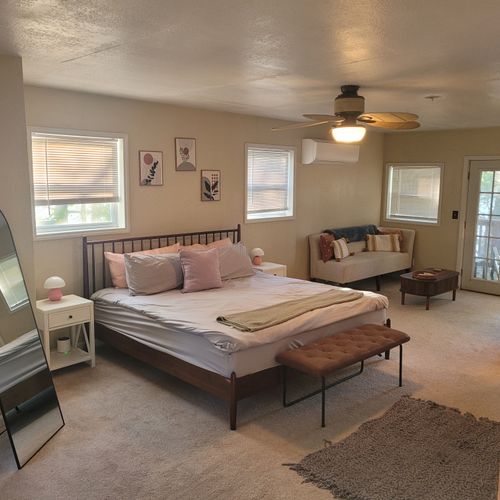 Bedroom #1:  the luxurious upstairs bedroom with an ensuite bathroom, a tv,  a closet, mini-split a/c unit, and private balcony