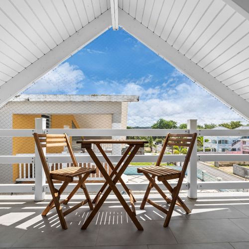 Perfect Balcony for Outdoor Dining. This balcony features a cozy table and chairs, creating an ideal setting for outdoor meals with a view.