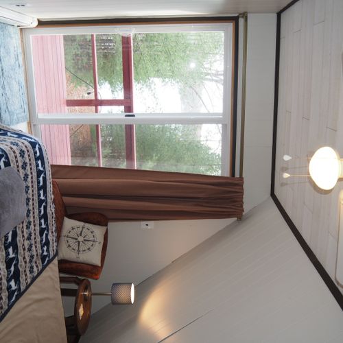 Bedroom #3 (second floor):  features a queen-size bed, walk-out balcony with lakeview, chair, nightstands with lamps, ceiling fan, and a closet.