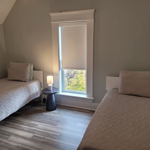 BEDROOM #4 (SECOND FLOOR):  Features 2 twin beds, window A/C unit (not shown), ceiling fan, nightstand, lamp, dresser, and a closet.