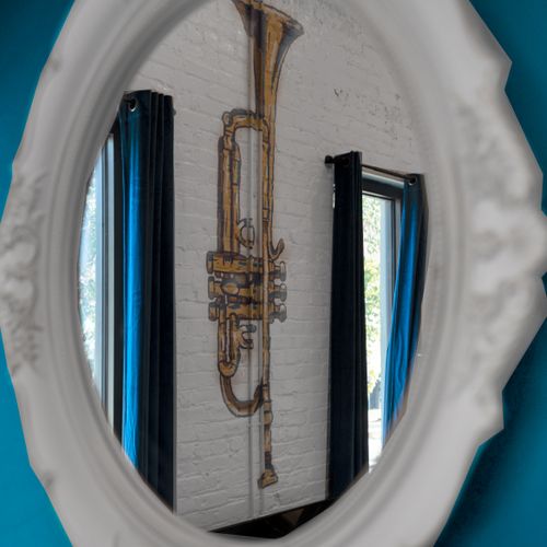 A saxophone reflected in a teal mirror captures the home's jazzy, artistic spirit.