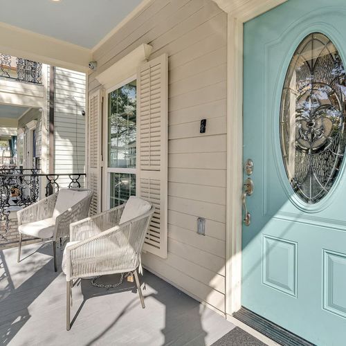 Bright entryway w/ bold teal door & stylish full-length mirror.