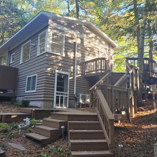 EXTERIOR:  The side of the house, highlighting the stairs up to the entrance on the second floor.