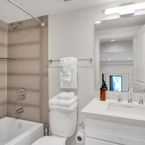 Enjoy a sparkling clean space with a full tub, fresh towels, and a wide vanity—perfect for getting ready or winding down.