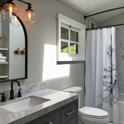 Guest bathroom is shared by two guest bedrooms upstairs. A second full bathroom is on the main floor with custom-tiled shower and vanity, and water closet.