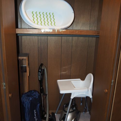 Hallway:  large storage closet at end of hallway with a vacuum cleaning, high chair, and laundry basket.