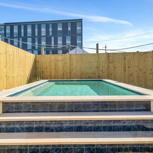 Sun-soaked pool tucked behind a tall wood fence — your own private escape.