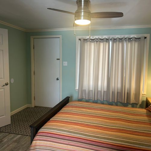 Bedroom:  cute bedroom with queen-size bed, ceiling fan, private streaming television, dresser, closet, nightstand, and lamp.
