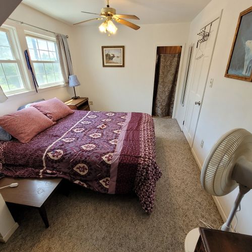 Bedroom #1 ( second floor):  large master bedroom with a queen-size bed, closet, vanity, ceiling fan, pedestal fan, and nightstand.
