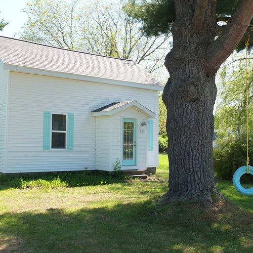 Exterior:  another angle of the front of the house, highlighting the large pine tree in the front yard as well as the tire swing.