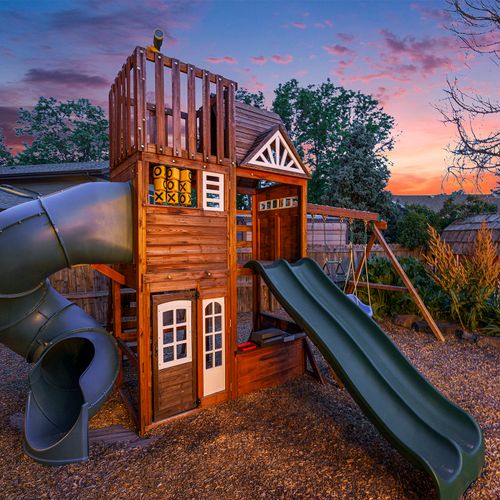 At dusk, the jungle gym casts playful shadows against the fading light, creating a whimsical and inviting atmosphere for children to enjoy their evening adventures.