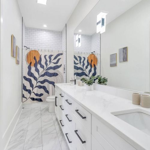 Upstairs Jack & Jill en-suite full bath w/ double sinks & fresh white finishes.
