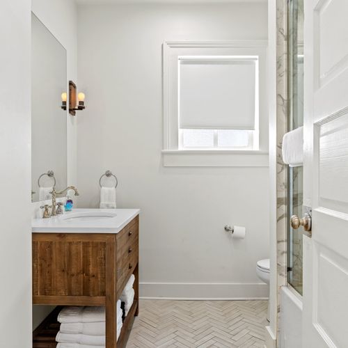 First bathroom with spacious shower and large mirror provided