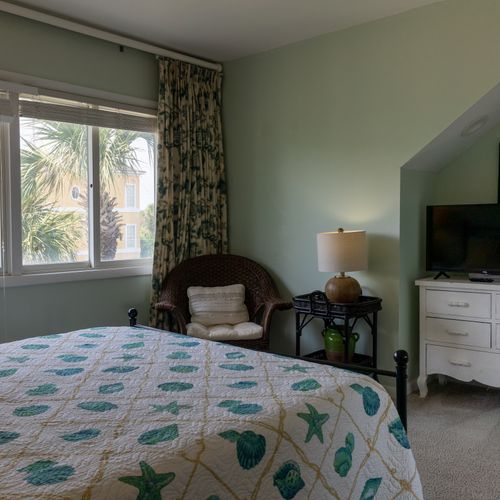 Relax in a comfortable queen-sized bed in the second bedroom with tv, dresser and accent seating for your convenience.