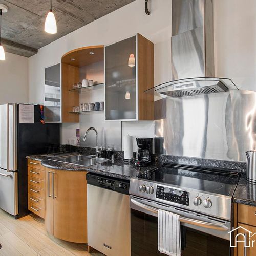 - fully stocked kitchen features sleek appliances and glossy granite countertops
- open shelving and vented range hood add style to the functional layout
- everything you need for cooking, from coffee to full meals, is right here