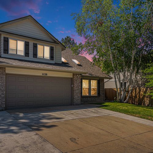 Welcoming two-story exterior with ample parking and leafy privacy.