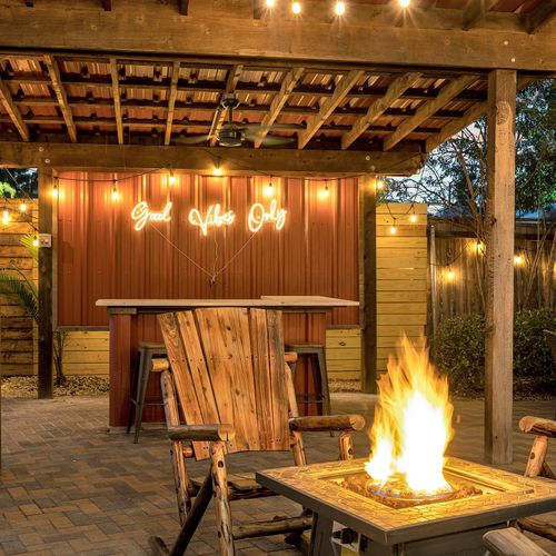 Cozy up by the firepit as the sun sets, surrounded by vibrant local art and twinkling string lights.