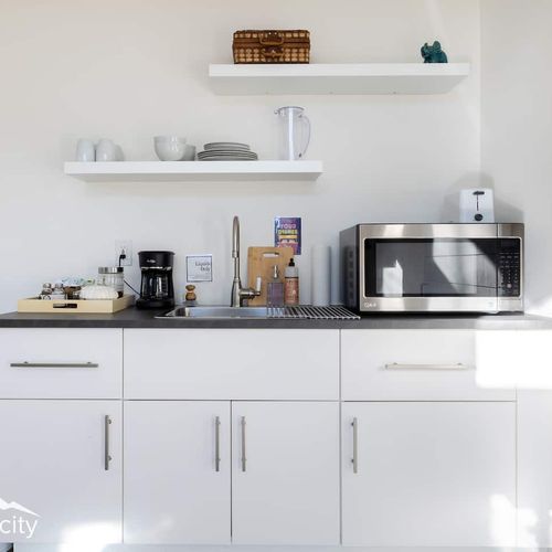 - bright, modern kitchenette with everything you need for a cozy, convenient stay
- features include a microwave, coffee station, open shelving, and stainless steel sink
- organized and minimalist design keeps the space functional and welcoming