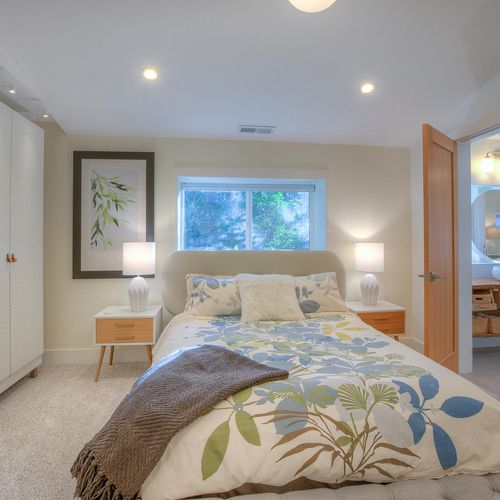 Guest bedroom with a queen bed and wardrobe and dresser.