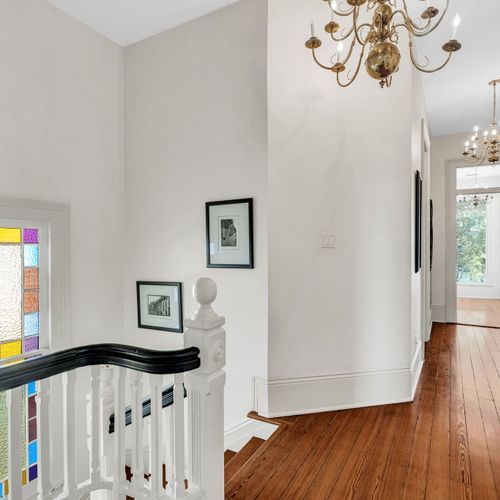 Charming hallway with stained glass and vintage chandeliers.