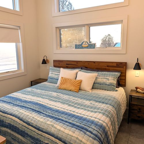 BEDROOM #3 (UPPER LEVEL):  Gorgeous top floor (third floor) bedroom with a king-size bed, nightstands, nightlamps, private television, dresser. closet, amazing view of Crystal Lake, and private entrance to the top floor bathroom!