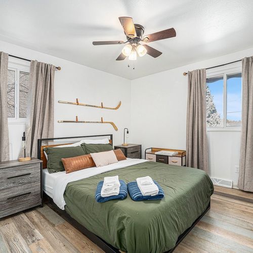 - rest easy in a comfy queen bed wrapped in fresh linens and layered pillows
- dual windows and neutral curtains invite in light while keeping things calm
- rustic textures meet sporty charm for a space that’s both fun and relaxing
