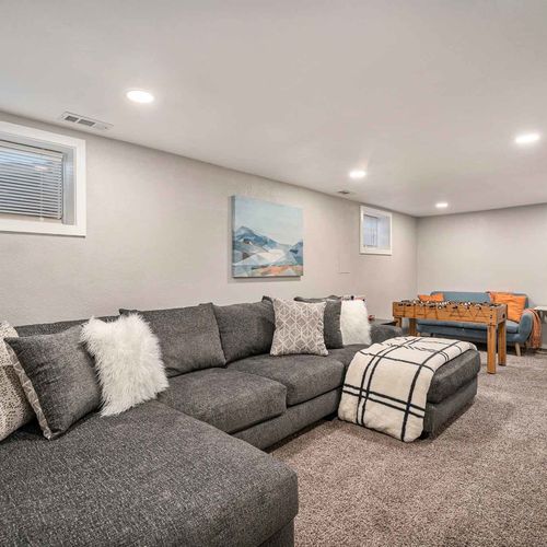 A captivating lounge space awaits in the lower level, complete with a foosball table and a widescreen tv.