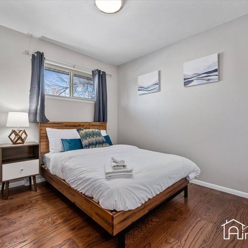 - inviting queen bedroom with wood platform bed, hardwood floors, and modern decor
- brightened by natural light from the wide window and accented with teal pillows
- great space for couples or solo travelers seeking comfort and calm
